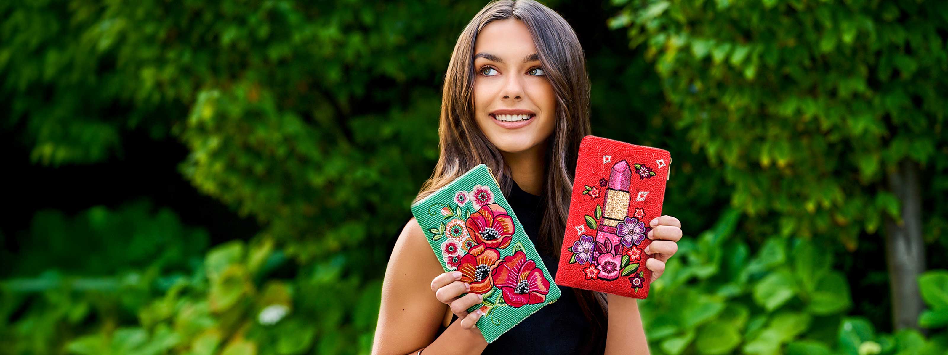 Model holding beaded crossbody phone bags poppy field and glamour girl