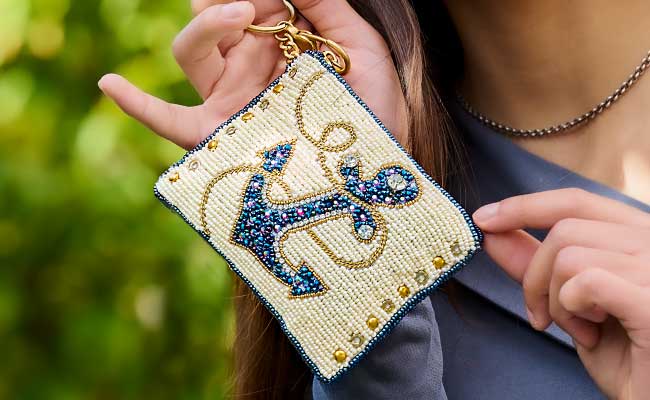 Model holding Hooked beaded anchor coin purse key fob